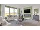 Spacious living room features a modern fireplace, ample seating, and large windows with natural light at 15400 Manderley St, Fishers, IN 46040