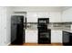 Efficient kitchen design with black appliances and white cabinetry at 162 Carmelaire Dr, Carmel, IN 46032