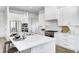 An open-concept kitchen features stainless steel appliances, a large island, and sleek white cabinets at 16457 Gleneagles Ct, Noblesville, IN 46060
