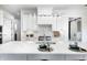 An open-concept kitchen features stainless steel appliances, a large island, and sleek white cabinets at 16457 Gleneagles Ct, Noblesville, IN 46060