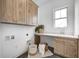 Well-appointed laundry room with wooden cabinets, sink, countertop, and space-saving front load washer and dryer hookups at 16457 Gleneagles Ct, Noblesville, IN 46060