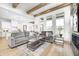 Open-concept living room flowing into the kitchen with neutral decor, wood beams, and large windows at 16457 Gleneagles Ct, Noblesville, IN 46060