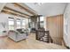 Bright living room featuring wood beams, modern fireplace, neutral decor, and staircase at 16457 Gleneagles Ct, Noblesville, IN 46060