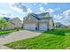 An exterior side view showing the lush green lawn and attached three-car garage at 1662 Cascade Dr, Greenwood, IN 46143