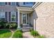Inviting front porch with decorative plants flanking the front door, with brick veneer siding at 1662 Cascade Dr, Greenwood, IN 46143