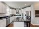 Bright kitchen featuring white cabinets, a stainless steel dishwasher, and a center island with black countertop at 1662 Cascade Dr, Greenwood, IN 46143