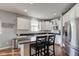 Well-lit kitchen with a center island, stainless steel refrigerator, white cabinets, and dark countertops at 1662 Cascade Dr, Greenwood, IN 46143