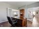 Bright home office featuring a wooden desk, hardwood floors, and access to living areas at 1662 Cascade Dr, Greenwood, IN 46143
