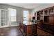 Office with dark wood desk, hardwood flooring, and natural light from large windows at 1662 Cascade Dr, Greenwood, IN 46143