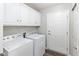Neat laundry room with white washer, dryer, and cabinets, offering a functional space at 16637 Brownstone Ct, Westfield, IN 46074