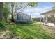 Backyard featuring a trampoline, detached garage, and covered patio with exercise equipment at 1725 Medford Ave, Indianapolis, IN 46222