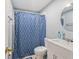 Clean bathroom with new fixtures, shower with curtain, and a bright round mirror at 1725 Medford Ave, Indianapolis, IN 46222