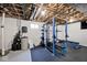 Basement gym featuring black rubber flooring, exposed ceiling, and blue weight rack at 19185 Rioux Grove Ct, Noblesville, IN 46062