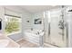 Well-lit bathroom with a soaking tub and glass door shower at 19185 Rioux Grove Ct, Noblesville, IN 46062
