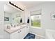 Bright bathroom featuring a dual sink vanity, soaking tub, and natural light at 19185 Rioux Grove Ct, Noblesville, IN 46062