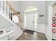 Bright foyer with a staircase, wainscoting, hardwood floors, and a decorative transom window at 19185 Rioux Grove Ct, Noblesville, IN 46062