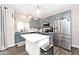 Modern kitchen with stainless steel appliances, an island with quartz countertops, and stylish pendant lighting at 19185 Rioux Grove Ct, Noblesville, IN 46062