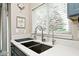 Close up on a kitchen sink with quartz countertops, stainless fixtures and bright natural light at 19185 Rioux Grove Ct, Noblesville, IN 46062