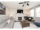 Cozy living room with a fireplace, large TV, plush sofa, and plenty of natural light at 19185 Rioux Grove Ct, Noblesville, IN 46062