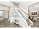 Elegant staircase with white risers, wood handrail, and a view into the dining room at 19185 Rioux Grove Ct, Noblesville, IN 46062