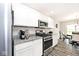 Modern kitchen with stainless steel appliances, granite countertops, white cabinets and gray wood floors at 19437 Astoria Ave, Sheridan, IN 46069