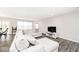Comfortable living room featuring a large sectional sofa, bright lighting, neutral walls, and gray wood floors at 19437 Astoria Ave, Sheridan, IN 46069