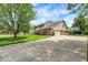 Beautiful home featuring a spacious driveway, well-manicured lawn, and mature trees providing ample shade at 195 Lake Dr, Greenwood, IN 46142