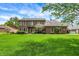 Charming two-story brick home featuring a lush green lawn, mature trees, and well-maintained landscaping at 195 Lake Dr, Greenwood, IN 46142