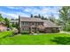 Two-story brick home showcasing lush green lawn and mature landscaping with flowering trees and shrubbery at 195 Lake Dr, Greenwood, IN 46142