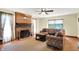 Cozy living room featuring a brick fireplace, ceiling fan, and a comfortable sectional sofa at 195 Lake Dr, Greenwood, IN 46142