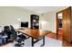 Well-lit office space featuring a large desk, hardwood floors, and a view into another room for connectivity at 195 Lake Dr, Greenwood, IN 46142