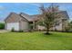 Beautiful single-story home with a well-manicured lawn, lush landscaping, and a tree at 2557 Cedarcrest Dr, Columbus, IN 47203