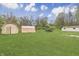 Sprawling backyard with multiple sheds and lush green lawn, offering plenty of storage and outdoor space at 3008 Old State Road 37, Greenwood, IN 46143