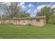 Spacious backyard featuring a charming brick home with a greenhouse and well-manicured lawn at 3008 Old State Road 37, Greenwood, IN 46143