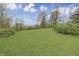 Rolling backyard with lush green grass and mature trees, offering privacy and natural beauty at 3008 Old State Road 37, Greenwood, IN 46143