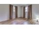 Simple bedroom featuring wood flooring, light walls, two windows, and neutral curtains at 3008 Old State Road 37, Greenwood, IN 46143