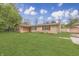 Low angle view of tan brick home with red shutters and a green lawn at 3008 Old State Road 37, Greenwood, IN 46143