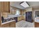 Kitchen with wooden cabinets, black appliances, and light-colored tiled floors with view into living room at 3008 Old State Road 37, Greenwood, IN 46143
