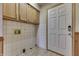 Functional laundry area with overhead cabinets, tile floor, and connections for appliances at 3008 Old State Road 37, Greenwood, IN 46143