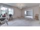 A carpeted living room featuring a chandelier, natural light and an open doorway to another room at 3008 Old State Road 37, Greenwood, IN 46143