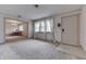 A bright, carpeted living room featuring neutral walls, large window, and front door at 3008 Old State Road 37, Greenwood, IN 46143