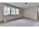 A bright, carpeted living room featuring neutral walls, a large window, and front door at 3008 Old State Road 37, Greenwood, IN 46143