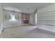 Spacious living room featuring a red brick fireplace, outdated wallpaper, lighting and carpeted floors at 3008 Old State Road 37, Greenwood, IN 46143