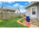 Grassy backyard with a brick path, wooden fence, and home exterior at 301 Colescott St, Shelbyville, IN 46176