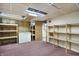 Finished basement area, showcasing wood shelving, a freezer, open ceiling, and pink carpeting at 301 Colescott St, Shelbyville, IN 46176