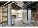 Unfinished basement with open ceiling, utility equipment, and built in shelving at 301 Colescott St, Shelbyville, IN 46176
