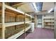 Finished basement area featuring wooden shelving, a freezer, wood panelling, and pink carpeting at 301 Colescott St, Shelbyville, IN 46176