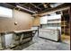 Unfinished basement with work bench, pegboard, cabinets, and open ceiling at 301 Colescott St, Shelbyville, IN 46176