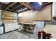 Unfinished basement with work bench, pegboard walls, cabinets and open ceiling at 301 Colescott St, Shelbyville, IN 46176