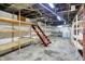 Unfinished basement with open ceiling, concrete floor, wooden shelves and a ladder at 301 Colescott St, Shelbyville, IN 46176